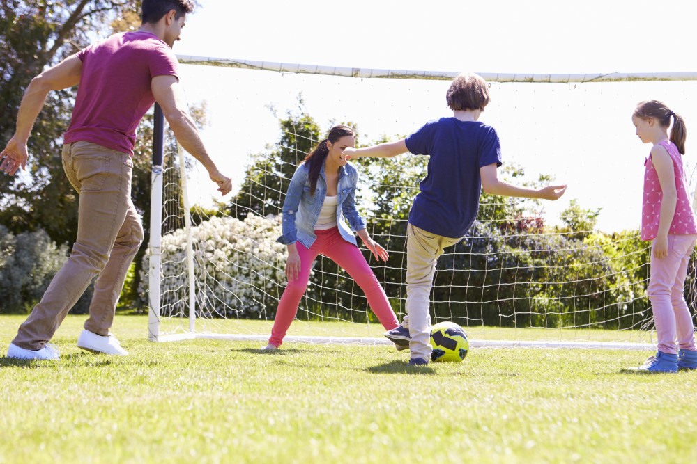 Familie der spiller fodbold i haven